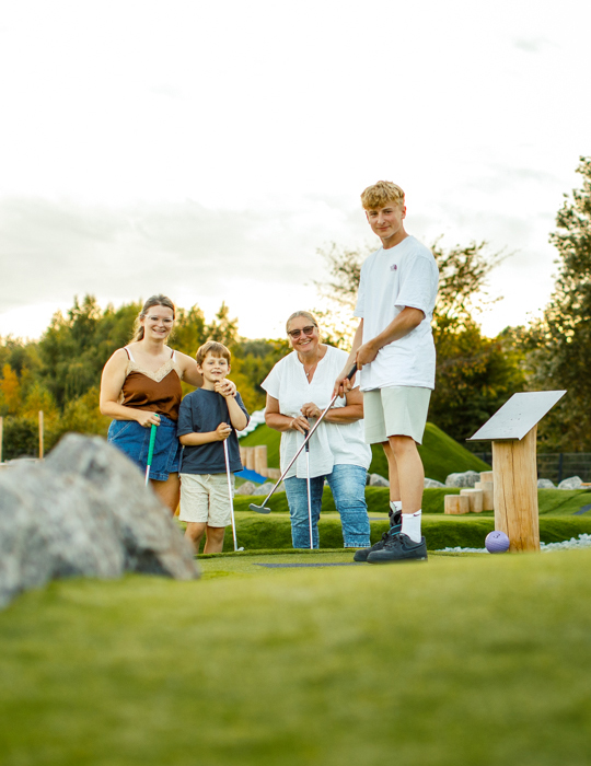 Familie beim Minigolf spielen