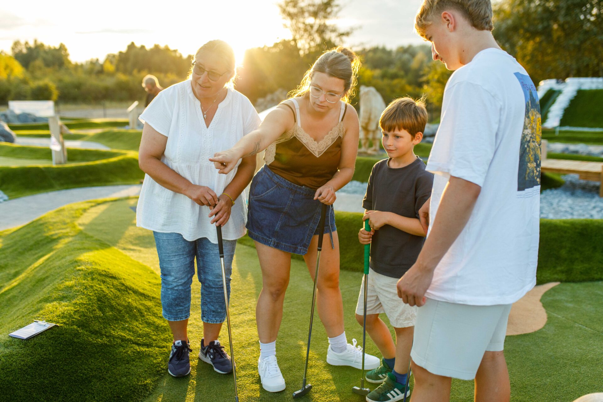 Familie spielt auf der Adventure Minigolf Anlage