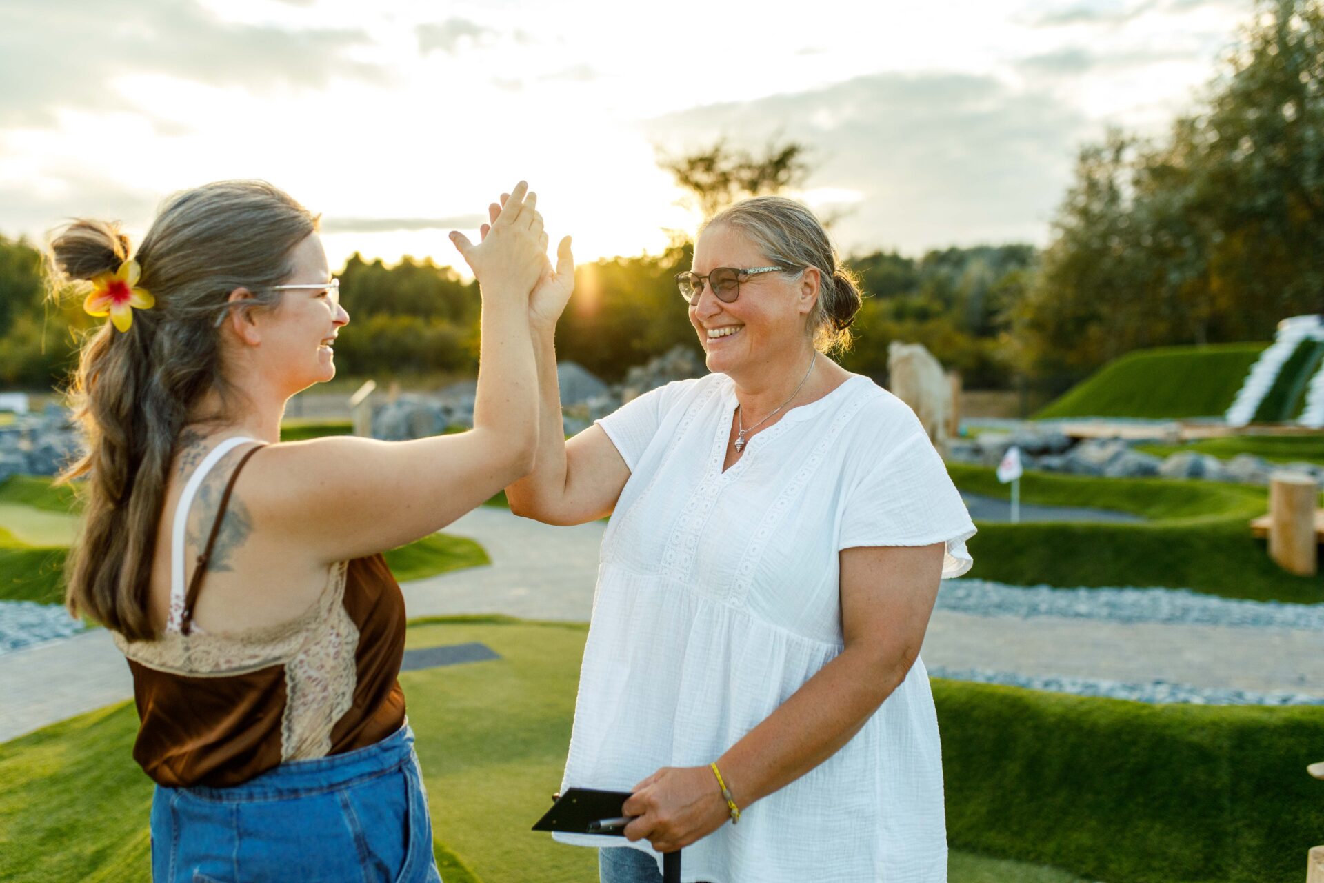 Zwei Spielerinnen geben sich beim Adventure Golf in Hooksiel ein High Five