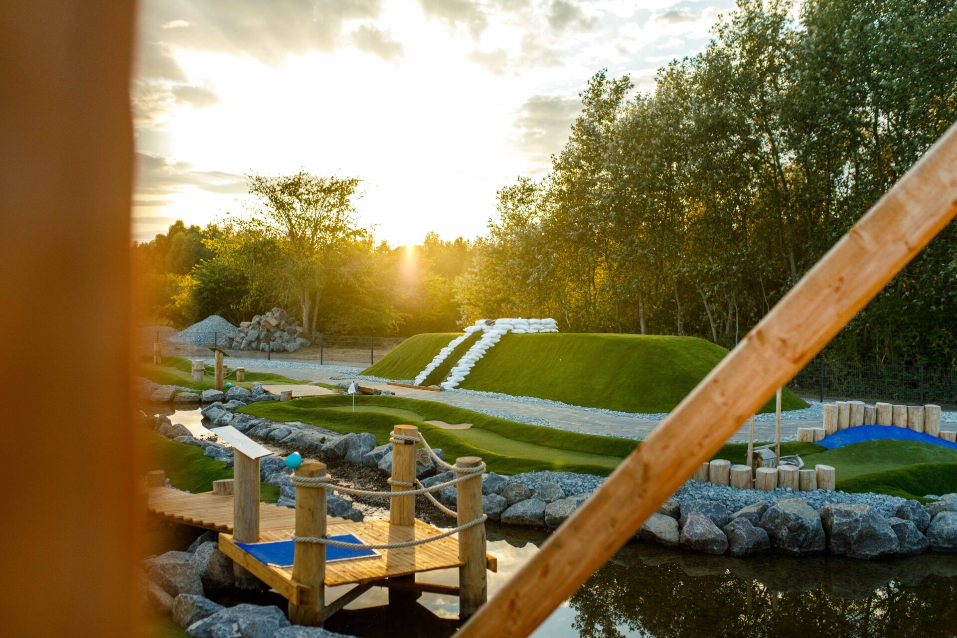 Adventure Golf Bahn mit Holzbrücke im Abendlicht in Hooksiel